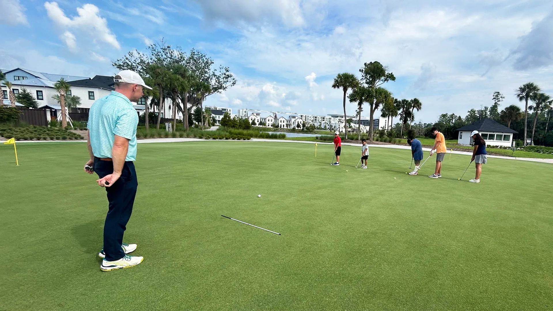 Grand Cypress Golf Junior Camp PGA Instructor An image of a PGA instructor teaching children about putting during a Grand Cypress Golf junior camp at Evermore Orlando Resort.
